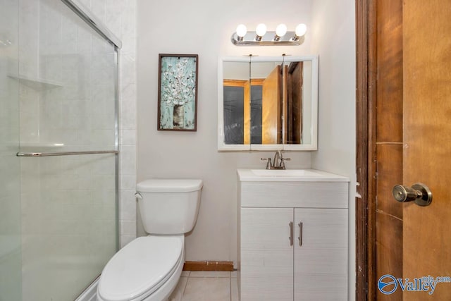 bathroom with vanity, toilet, a shower with door, and tile patterned flooring