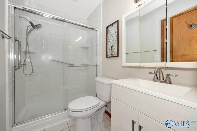 bathroom featuring vanity, toilet, a shower with shower door, and tile patterned flooring