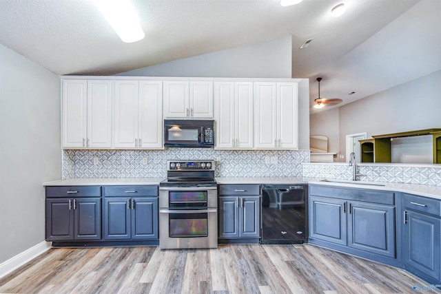 kitchen featuring black appliances, backsplash, light wood-type flooring, sink, and vaulted ceiling