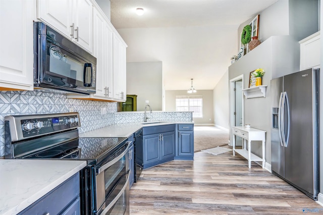 kitchen with black appliances, blue cabinetry, white cabinets, and light wood-type flooring