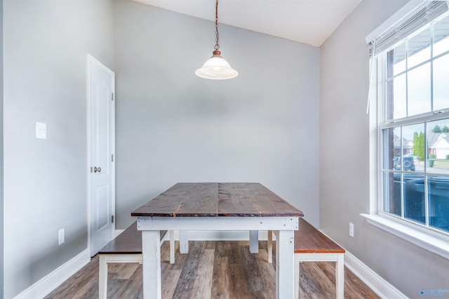 unfurnished dining area with wood-type flooring and lofted ceiling