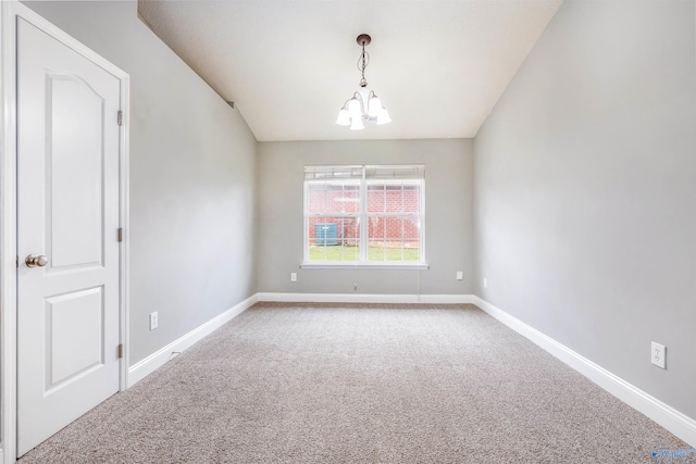 carpeted empty room with an inviting chandelier