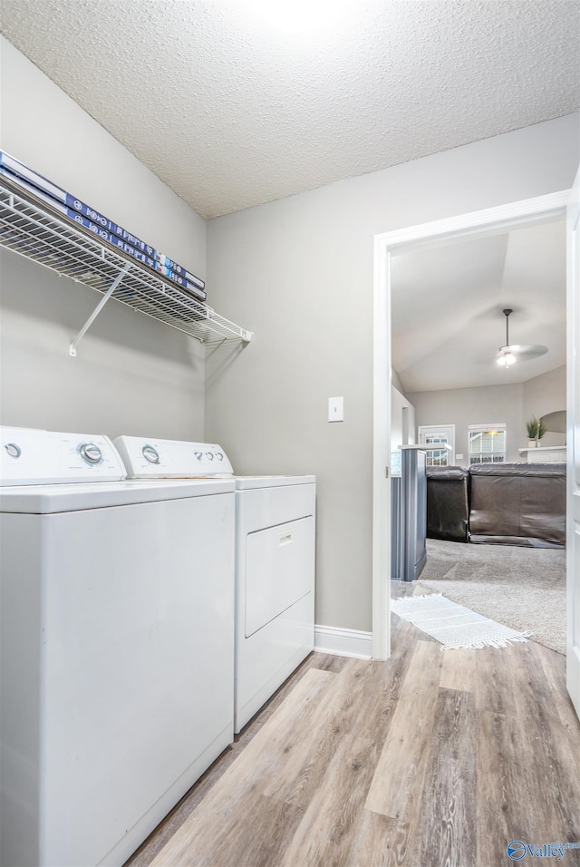 laundry area featuring ceiling fan, a textured ceiling, light hardwood / wood-style flooring, and independent washer and dryer