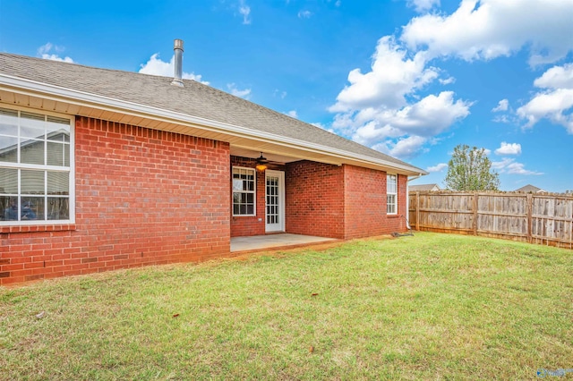 back of house with ceiling fan, a lawn, and a patio area