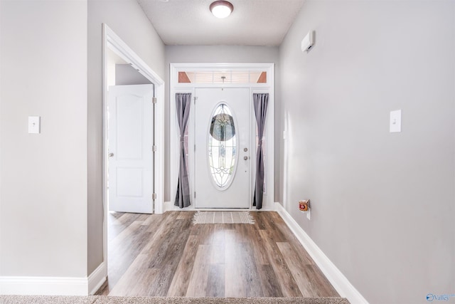 entryway featuring a textured ceiling and light hardwood / wood-style flooring