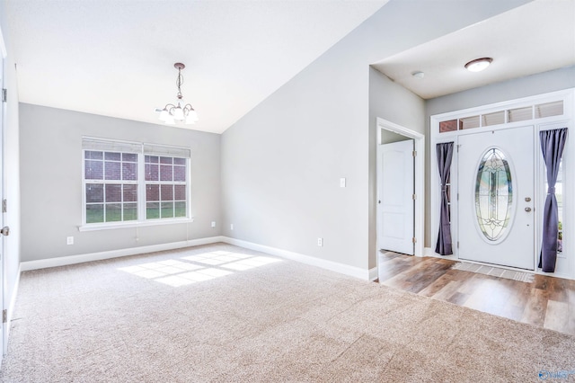 entryway with light wood-type flooring, lofted ceiling, and a chandelier