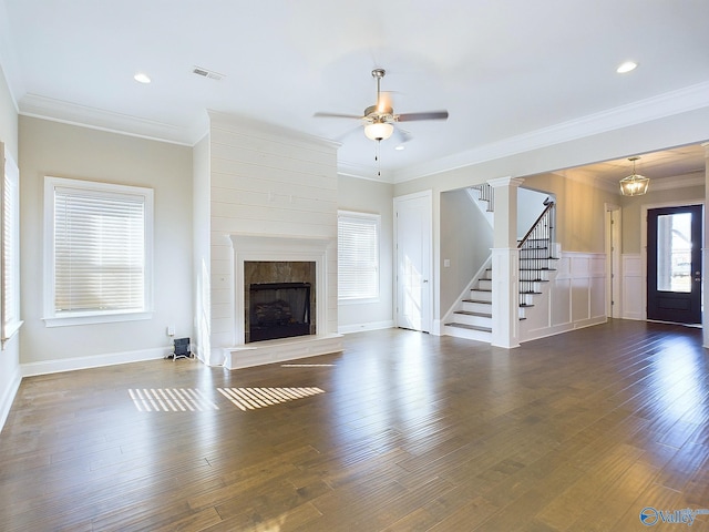 unfurnished living room with ceiling fan with notable chandelier, dark hardwood / wood-style floors, and ornamental molding