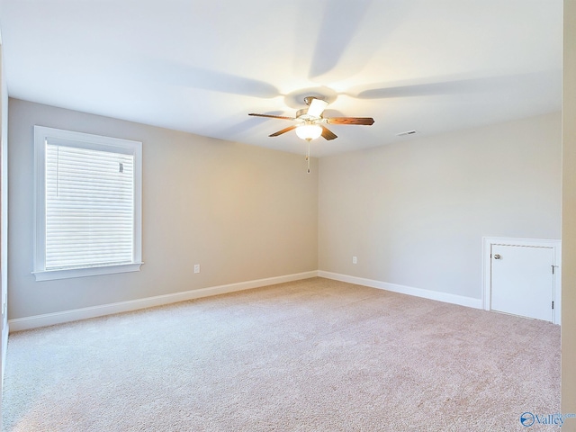 empty room with ceiling fan and light colored carpet