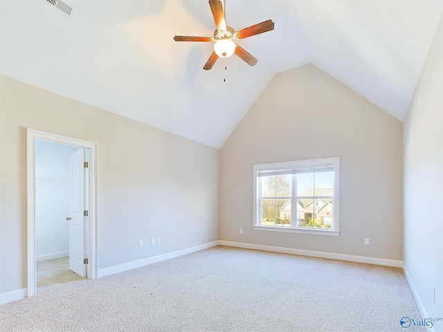 empty room with ceiling fan, light colored carpet, and lofted ceiling