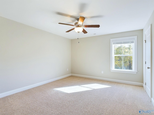 spare room with ceiling fan and light colored carpet