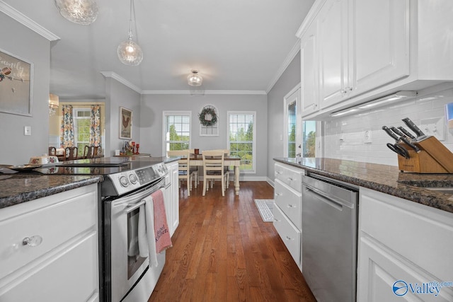 kitchen with dark stone countertops, white cabinetry, stainless steel appliances, and crown molding