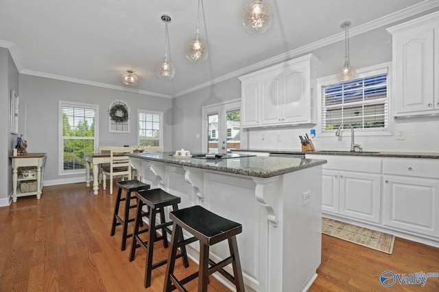 2961 Hobbs Island Rd SE, Huntsville, AL 35803 - kitchen with decorative backsplash, a center island, wood finished floors, dark stone counters, and white cabinetry
