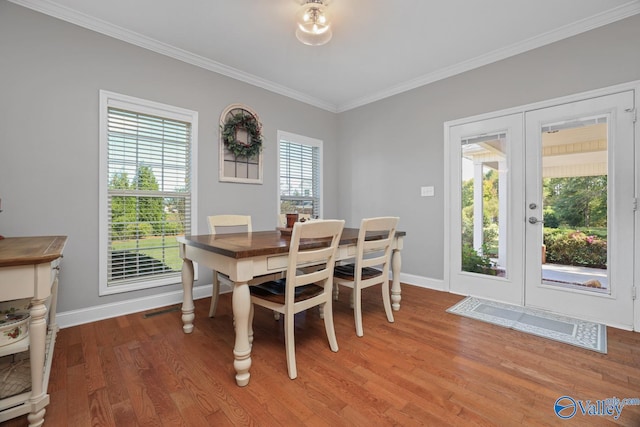 dining room featuring french doors, hardwood / wood-style flooring, and crown molding