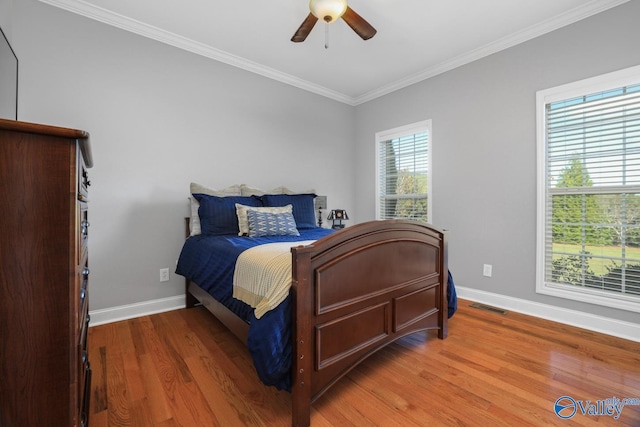 bedroom featuring ceiling fan, wood-type flooring, and ornamental molding