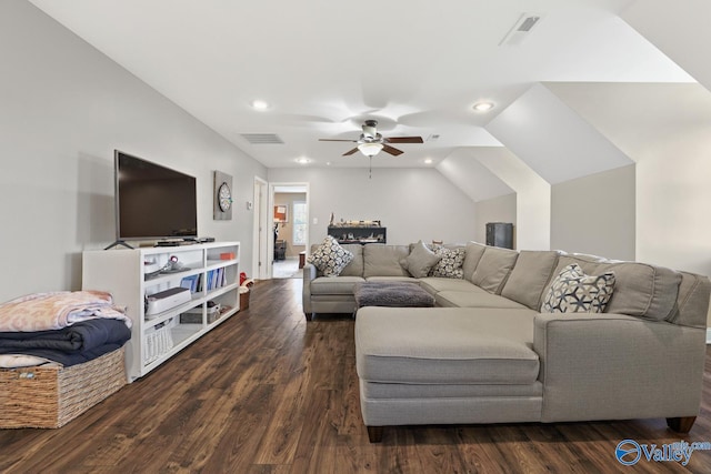 living room featuring dark wood-type flooring, vaulted ceiling, and ceiling fan