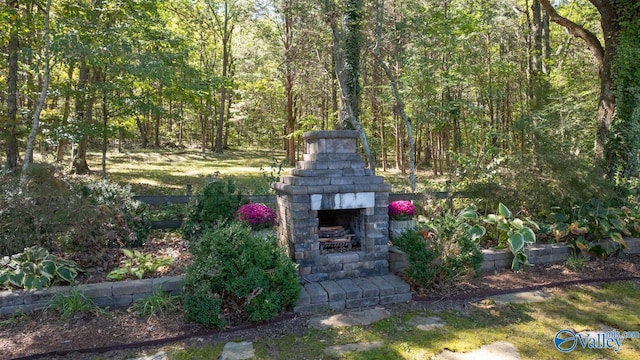 view of yard featuring an outdoor fireplace