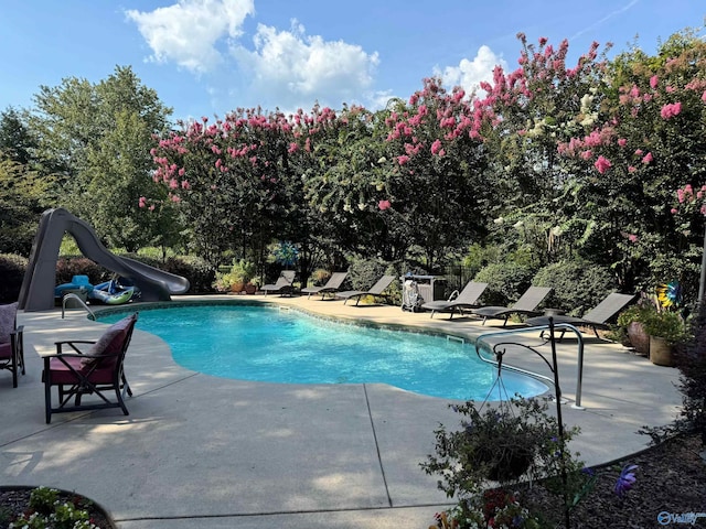 view of pool featuring a patio and a water slide