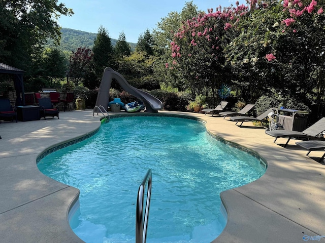 view of pool with a patio area and a water slide