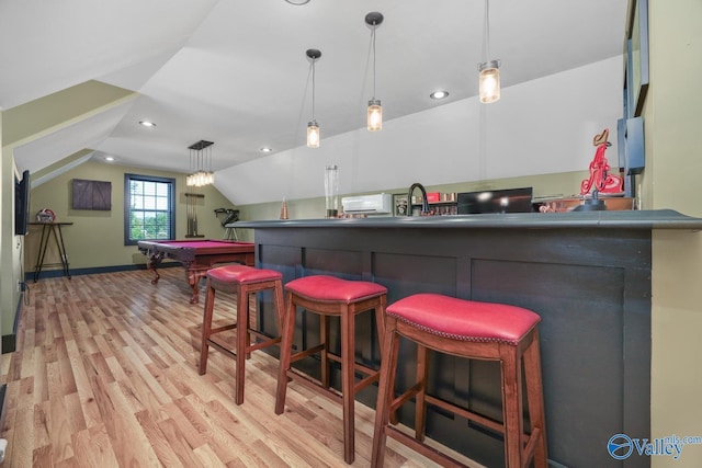 bar with hanging light fixtures, light wood-type flooring, lofted ceiling, and sink