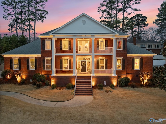 neoclassical home featuring a porch, a balcony, brick siding, crawl space, and stairway