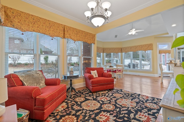 sunroom / solarium featuring ceiling fan with notable chandelier