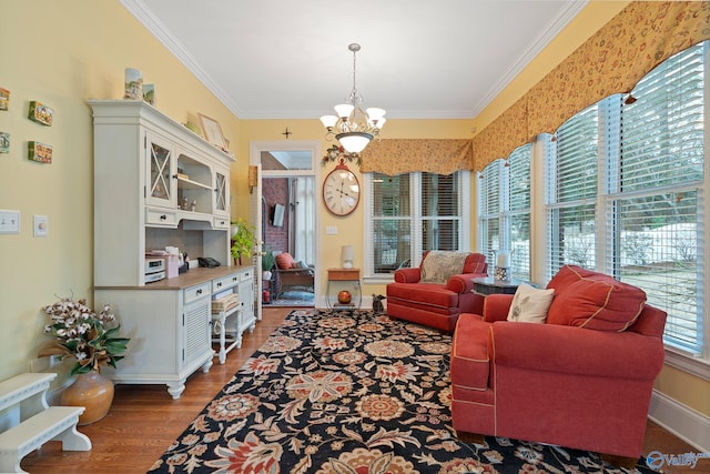 sitting room featuring a chandelier, ornamental molding, wood finished floors, and baseboards