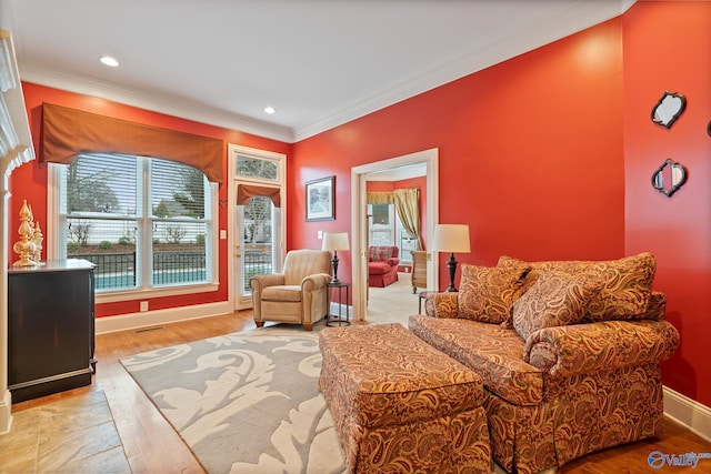 sitting room with ornamental molding, recessed lighting, wood finished floors, and baseboards