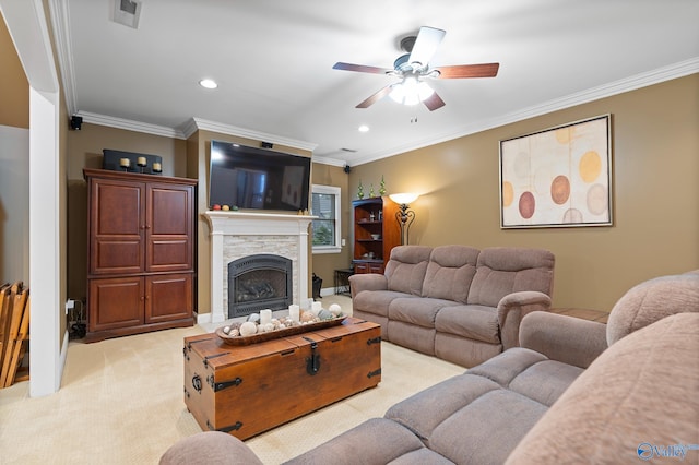 living room featuring light carpet, a fireplace, visible vents, a ceiling fan, and ornamental molding