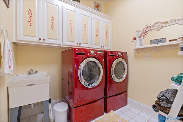 washroom with light tile patterned floors, cabinet space, baseboards, and separate washer and dryer