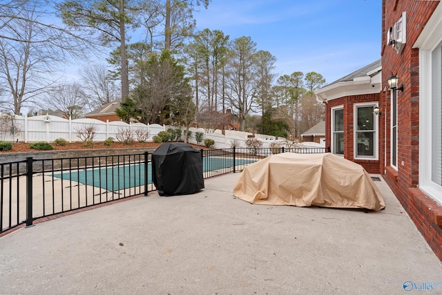 view of pool with a fenced in pool, a fenced backyard, a grill, and a patio