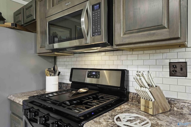 kitchen featuring appliances with stainless steel finishes, light stone counters, and decorative backsplash