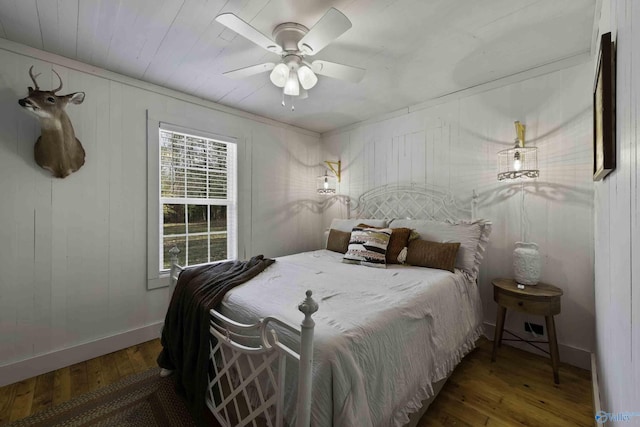 bedroom with ceiling fan, baseboards, and hardwood / wood-style flooring