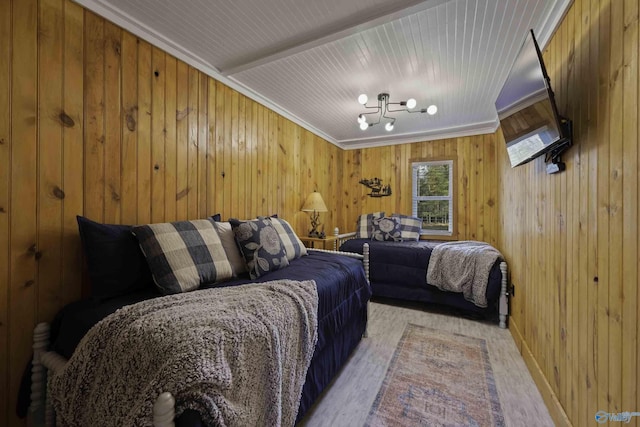 bedroom with light wood-type flooring, wood walls, and ornamental molding