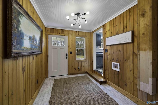 doorway featuring light wood-style floors, crown molding, and wood walls