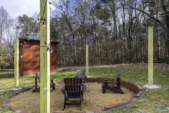 view of yard featuring an outbuilding, a storage shed, and a fire pit