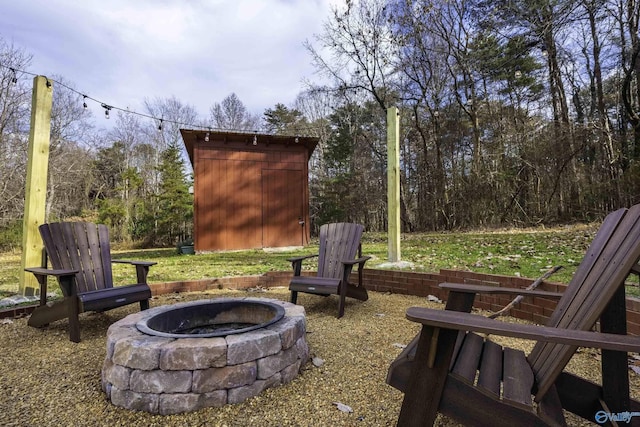 view of yard featuring an outbuilding, a shed, and an outdoor fire pit