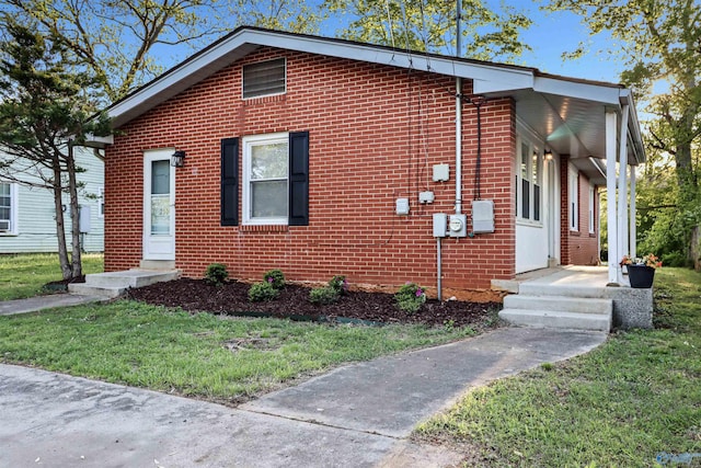 view of front of house with a front yard and brick siding
