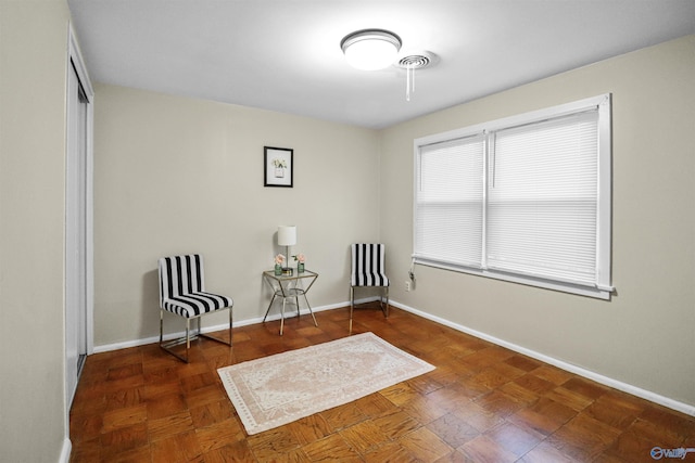 living area with visible vents and baseboards