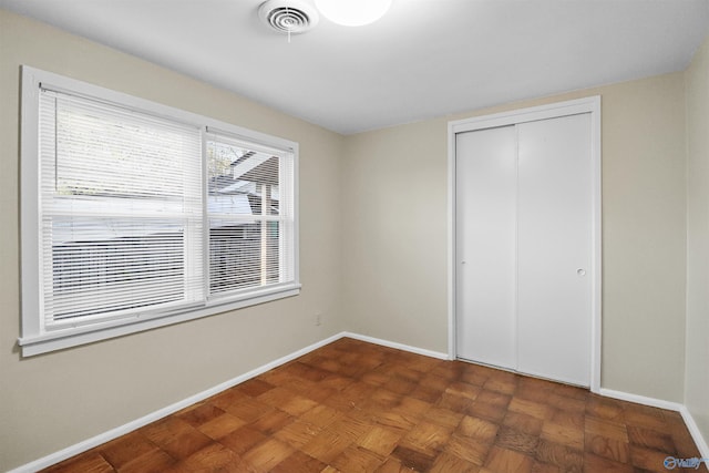 unfurnished bedroom featuring a closet, baseboards, and visible vents
