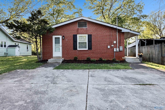 bungalow-style home with a front yard, brick siding, and fence