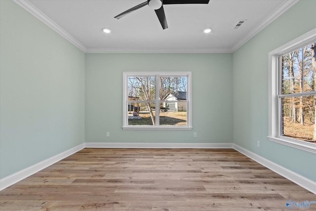 spare room featuring light hardwood / wood-style floors, ornamental molding, and a wealth of natural light