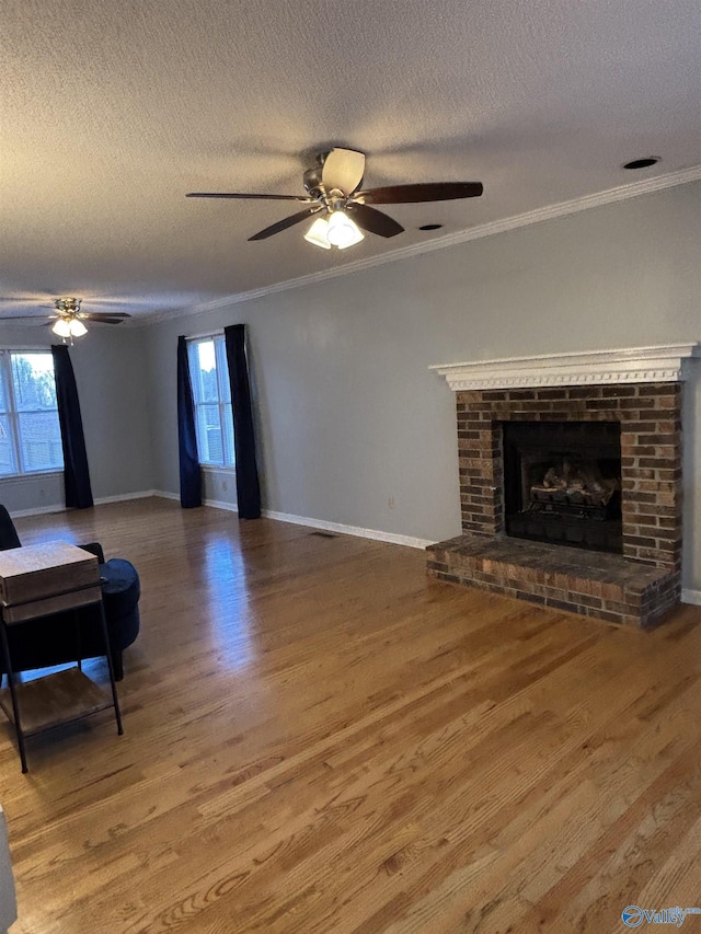 living area featuring a brick fireplace, plenty of natural light, and wood finished floors