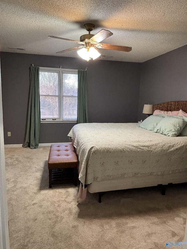 carpeted bedroom featuring a ceiling fan, a textured ceiling, and baseboards