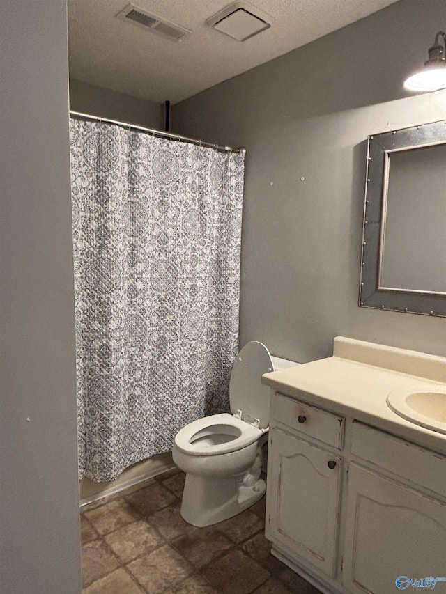 bathroom featuring toilet, a shower with shower curtain, vanity, and visible vents