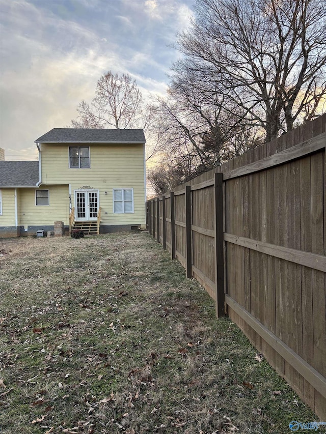 back of house with entry steps, a fenced backyard, and french doors