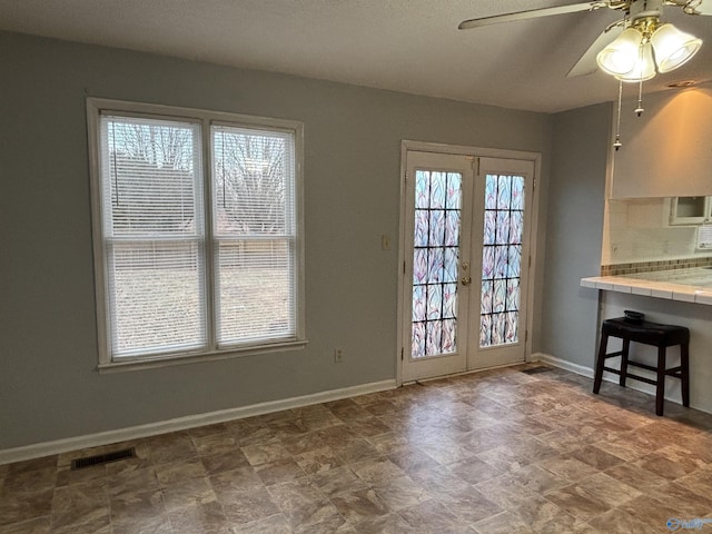 interior space featuring visible vents, plenty of natural light, and baseboards