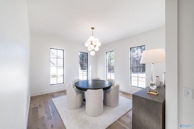 dining area with a notable chandelier and light hardwood / wood-style flooring