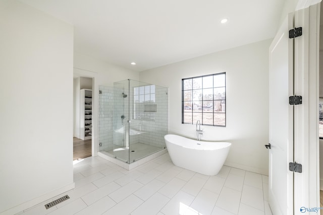 bathroom featuring tile patterned floors and separate shower and tub