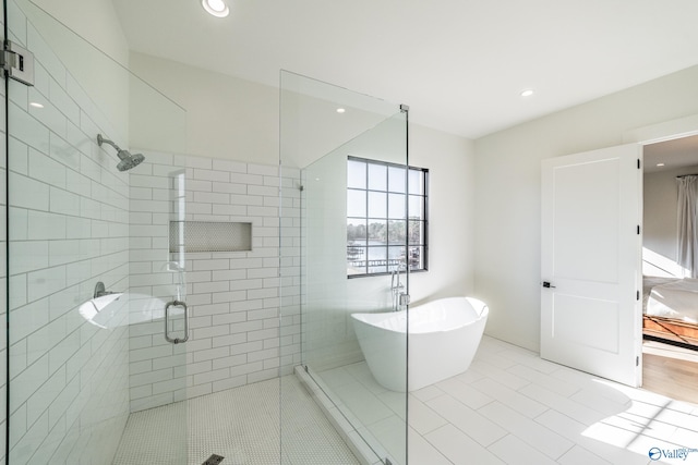 bathroom featuring tile patterned flooring and shower with separate bathtub