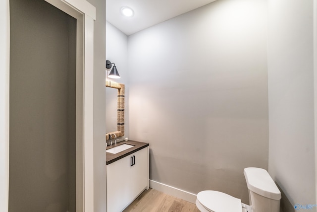 bathroom featuring vanity, hardwood / wood-style flooring, and toilet